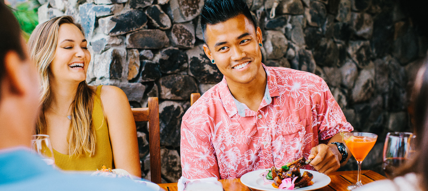 man smiling while eating his food